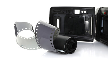 Roll of photographic film and photo camera isolated on white