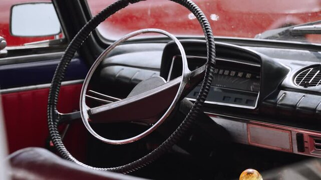Steering wheel and instrument panel in interior of retro car. Original interior and its details of vintage youngtimer without people with natural light.