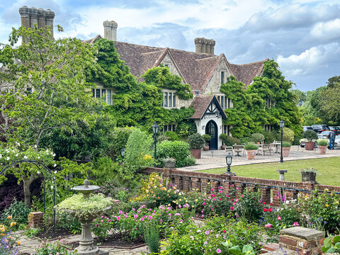 Ashford, Willesborough, England, UK - May 26, 2025. Charming historic facade of Boys Hall in Kent, England, adorned with lush green wisteria at the end of May. The elegant 17th-century country house 