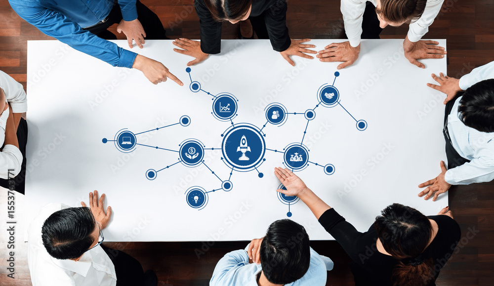 Poster a diverse group of professionals engages in a collaborative meeting, pointing at a central graphic r