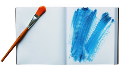 A paintbrush rests beside a vibrant blue paint stroke on the open page of a notebook isolated on white background