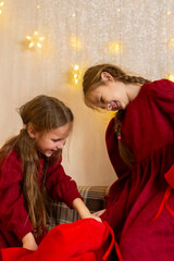 Little sisters girls on eve Christmas fighting with pillows at Christmas interior
