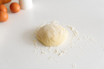 Preparing homemade tagliatelle pasta on on white table: dough and ingredients. Top view