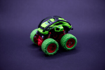 Spring toy car with green monster truck on purple spring, perfect for childrens products, toys, vehiclethemed designs, and springtime promotions.