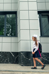 little kid girl with school satchel on first day to school. Back to school concept