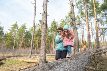 grandmother with granddaughter walking and playing in nature in the forest