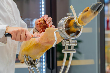 Spanish iberian ham cutting on a restaurant by a professional waiter with expertise in tapas