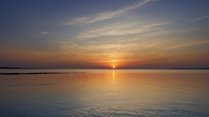 Serene Sunset Over Calm Water With Soft Hues Reflecting on the Surface at a Lakeside Location During Twilight Hours