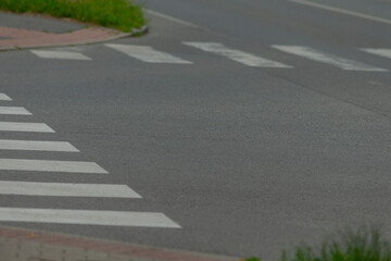Obraz premium Here is a detailed closeup view of a crosswalk located on the side of a busy road, highlighting its various features and surroundings