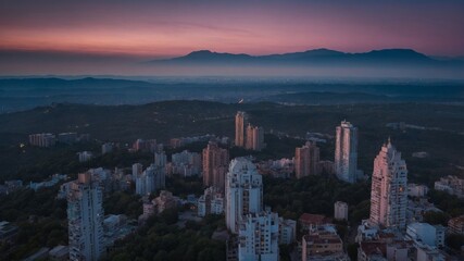 Fototapeta premium Skyline View of Urban City Surrounded by Mountains During Twilight With a Soft Gradient in the Sky