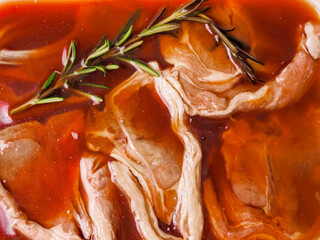 Premium quality marinated lamb loin chops and rosemary herb. Uncooked raw meat on the bone in red...