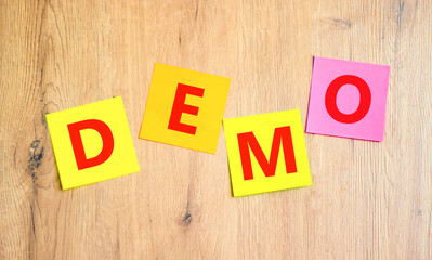 Demo symbol. Concept word Demo on beautiful colored paper. Beautiful wooden table wooden...