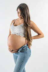 Beautiful Latin pregnant woman.
Serene expecting woman wearing jeans