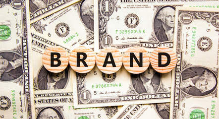 Brand symbol. Concept word Brand on beautiful wooden circles. Beautiful dollar bills. Beautiful...