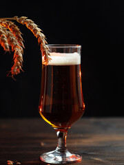 Beer glass on wooden table, wheat ears