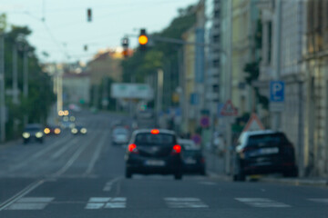 A somewhat unclear and blurry picture captures a busy city street where various cars are driving...
