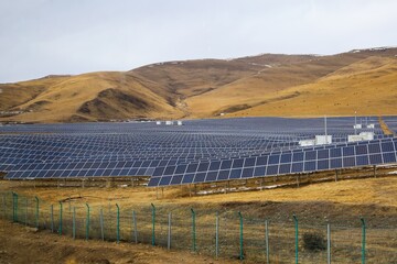 Large-scale solar panel farm on rolling hills near Ngawa in the historical Amdo region of Tibet,...
