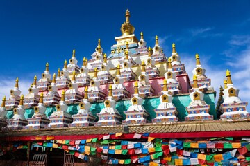 Colorful Vache Stupas (Waqietalin) adorned with prayer flags at Zoigê Marsh in the historical Amdo region, a unique Tibetan Buddhist site in Greater Tibet.

