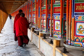 Tibetan monks spin colorful prayer wheels during the Butter Lamp Festival at Labrang Monastery, a...