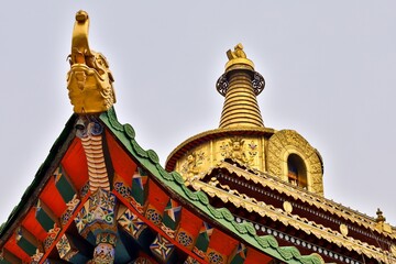 Golden stupa and colorful roof detail of Taktsang Lhamo Monastery in Langmusi, a sacred Tibetan Buddhist site in the Amdo region of Greater Tibet (now Gansu).