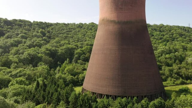Massive Industrial Cooling Tower Surrounded by Dense Green Forest