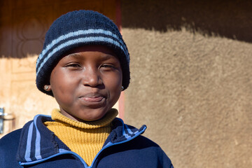 village single young african girl in school uniform standing in front of the house , in the yard,...