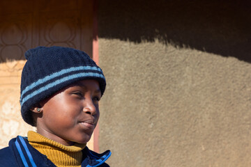 village single young african girl in school uniform standing in front of the house , in the yard,...