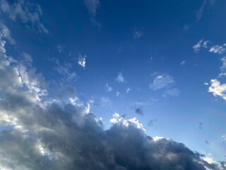 A serene sky features a blend of fluffy clouds against a vibrant blue backdrop, perfect for...