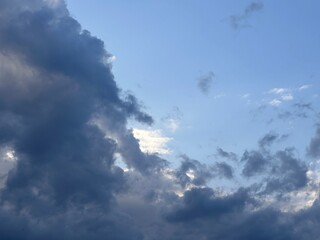 Dramatic clouds swirl in the evening sky, showcasing a blend of blues and grays. an atmospheric...