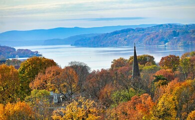 autumn landscape with a river and church steeple 