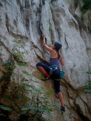 Woman Climbing a Rock Wall with Safety Helmet