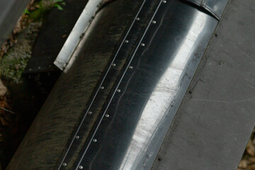 A detailed closeup photograph showcasing a metallic pipe that features several holes strategically...