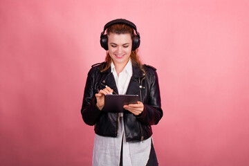 Woman with headphones, listening to music, fashion model in studio posing, music genre, smiling, rock, metal music , tablet