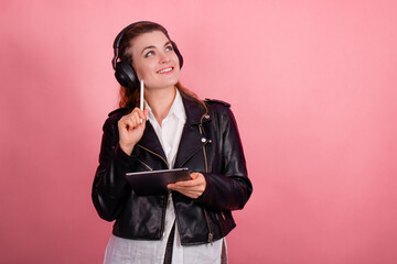 Woman with headphones, listening to music, fashion model in studio posing, music genre, smiling, rock, metal music , tablet