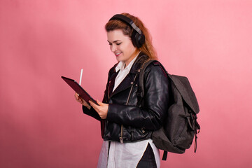 Woman with headphones, listening to music, fashion model in studio posing, music genre, smiling, rock, metal music , tablet