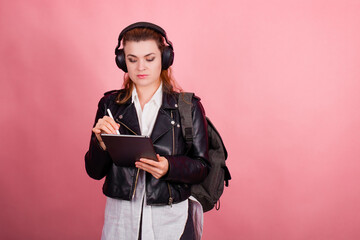 Woman with headphones, listening to music, fashion model in studio posing, music genre, smiling, rock, metal music , tablet