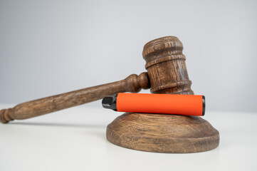 Judge's gavel and e-cigarette. Smoking ban. Tobacco heating systems. 