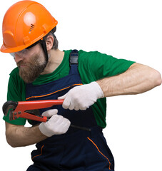 A male plumber installs a radiator in the heating system of an apartment. Guy in overalls and a gas...