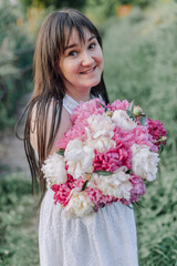 In combination with nature and flowers, harmony with oneself, happy moments, peace and balance. A charming girl in nature.