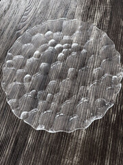 Transparent plate on wooden background
