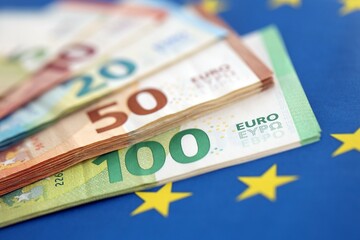 European eur currency money bills on Euro union blue flag close up
