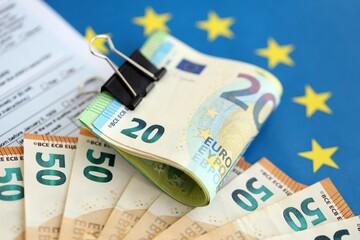 European euro currency money notes bunch on tax form and European union blue flag close up