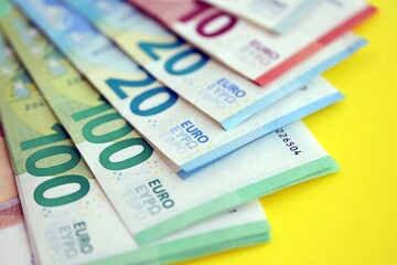 Big amount of european euro currency money notes on yellow color table close up