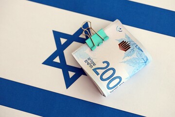 Israel New Shekels banknotes on national flag. The current Israel money bills lies on flag in big...