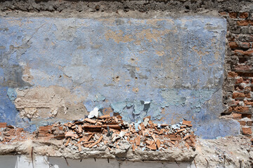 Textured Wall with Peeling Blue Paint, Exposed Bricks and Debris