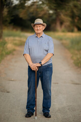 Grandfather in a hat. Portrait of a very old Caucasian man. Portrait: elderly, lonely, elderly, with many wrinkles on his face. Close-up of a thoughtful old man standing alone outdoors.