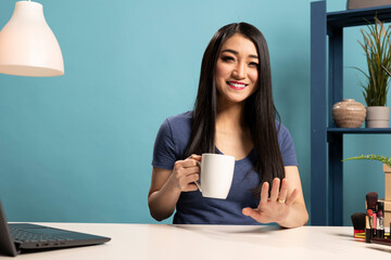 Portrait of beauty influencer smiling and speaking to online audience during a live broadcast in a...