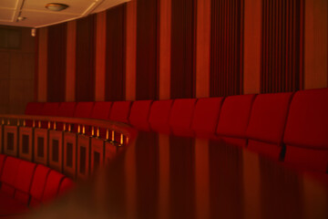 old theater interior , cinema. red chairs. empty seats background . beautiful colored light, interior