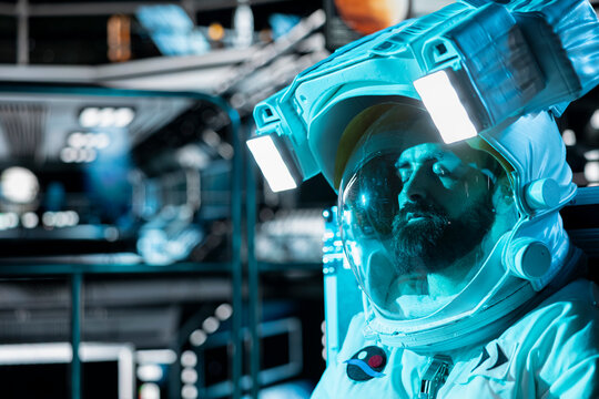 Close up of fatigued astronaut falling asleep in starship during long distance planetary mission. Tired man in space station wearing helmet sleeping on floor during cosmic trip to other planets