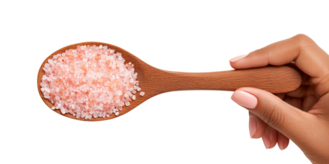 Wooden spoon of Himalayan pink salt crystals in hand